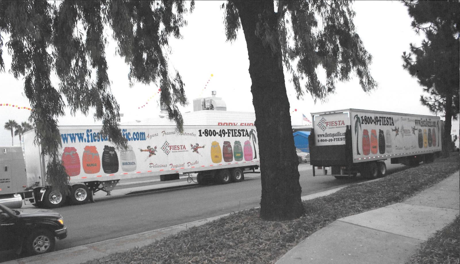 Two Fiesta semi trailers parked on a street, both with matching wrap graphics